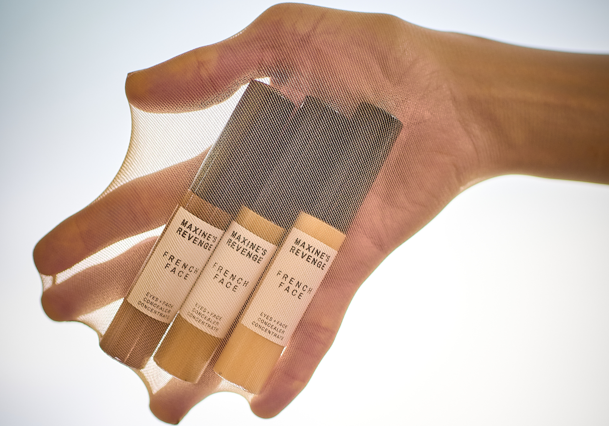 Hand holding 3 bottles of Maxine's Revenge French Face in stretchy nylons