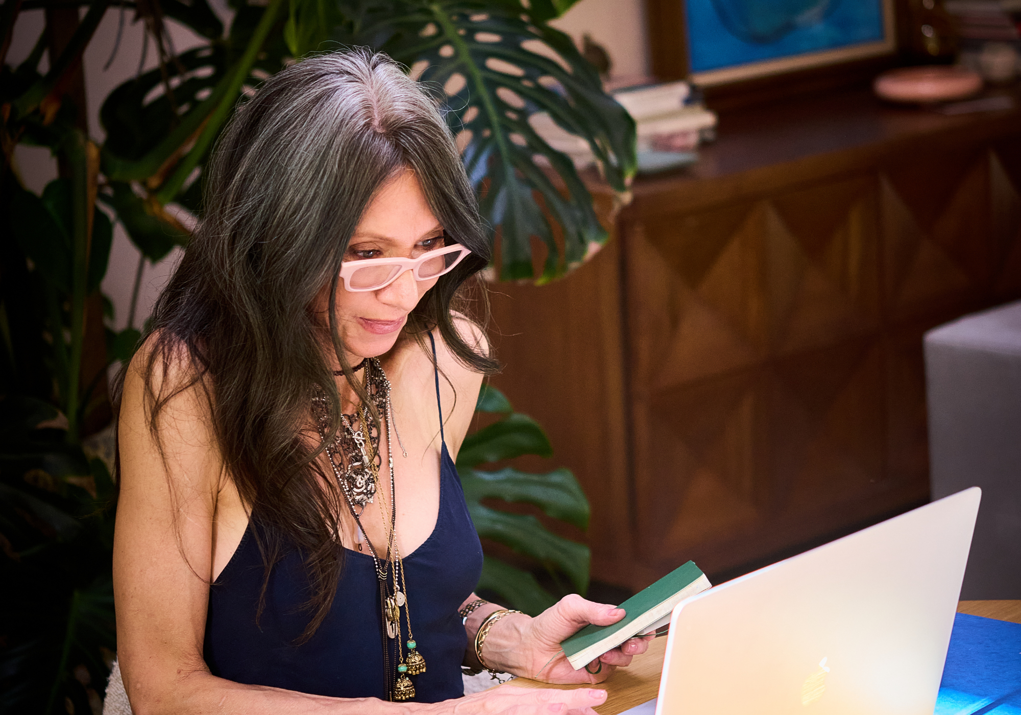 Leah using a laptop in a casual setting with plants and furniture in the background