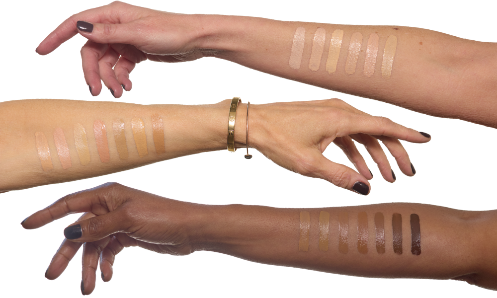 Three different skin toned arms with French Face concealer swatches on their skin, all against a white background